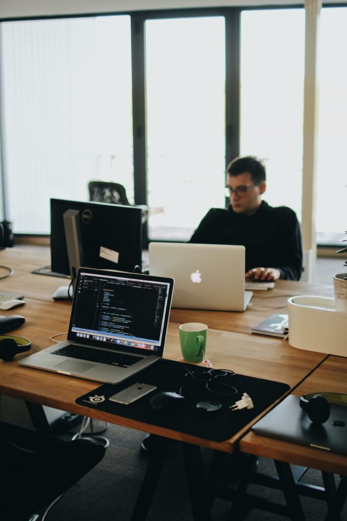 pexels-photo-2102416-2102416 A web developer working on code in a modern office setting with multiple devices.
