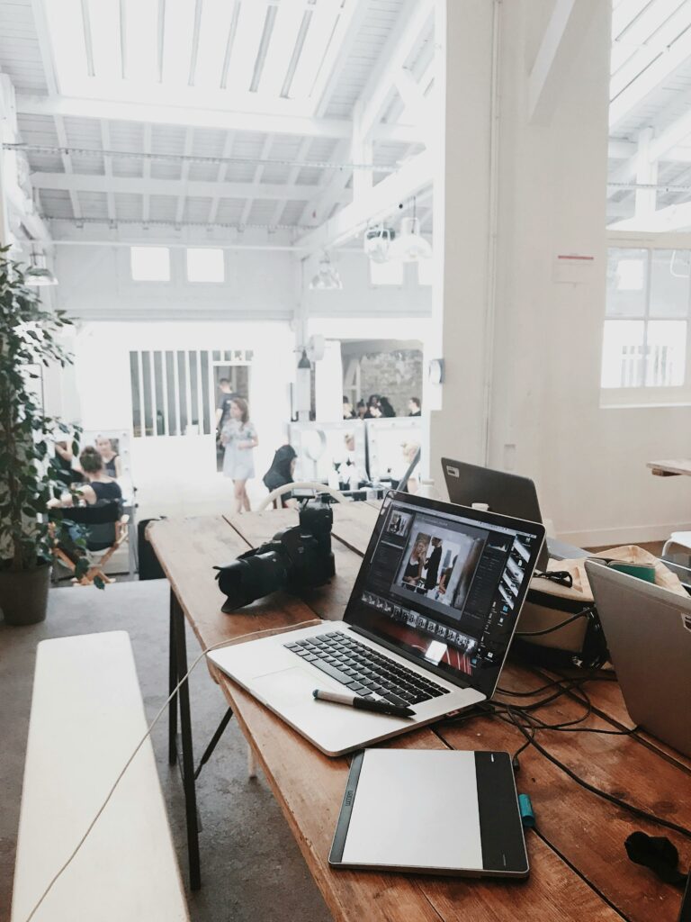 pexels-photo-699459-699459 A bright, modern workspace featuring laptops, a camera, and a drawing tablet in an indoor office.